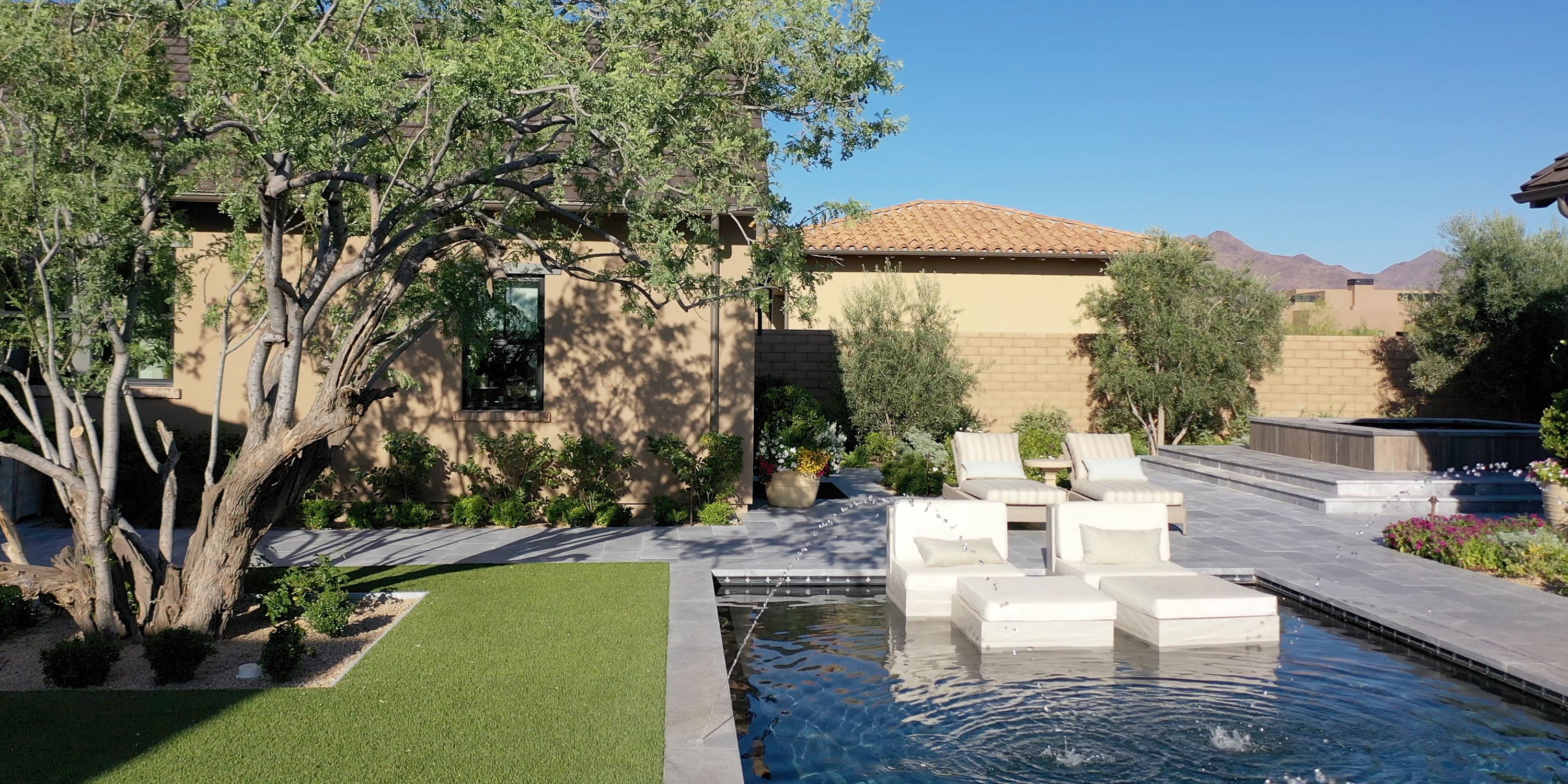 Contemporary backyard with pool, spa, lounge chairs, and manicured landscaping