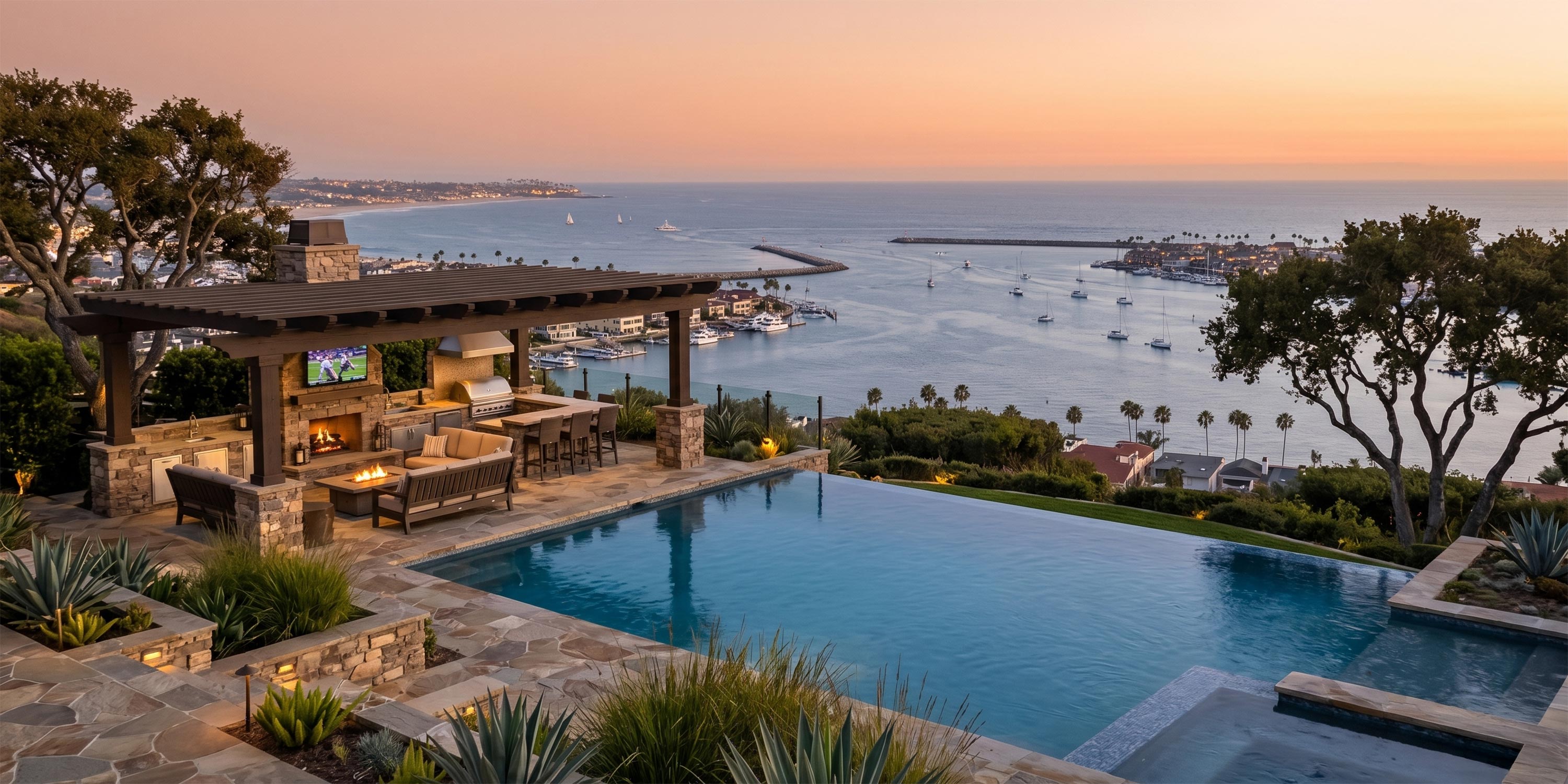 Luxury outdoor kitchen and patio pavilion next to an infinity pool overlooking a bay